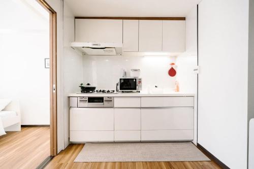 a kitchen with white cabinets and a microwave at 夏美ホテル in Tokyo