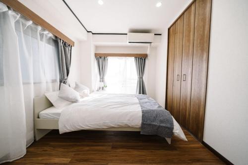 a small bedroom with a bed and a window at 夏美ホテル in Tokyo