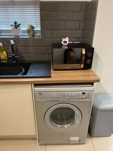 a microwave sitting on top of a washing machine at Cairo Street Ground New in Warrington