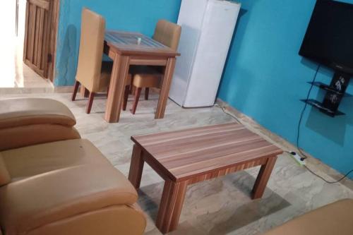 a living room with a couch and a table at Cozy quiet 1 bedroom with kitchen in Ibadan