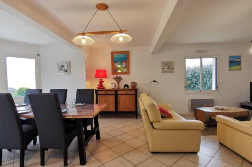 un salon avec une table et des chaises de salle à manger dans l'établissement Grande maison spacieuse et lumineuse tout confort, à Plozévet