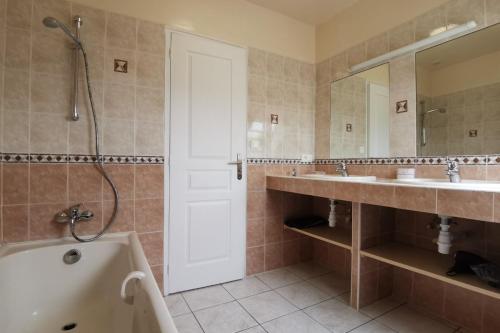 une salle de bain avec deux lavabos, une baignoire et une douche dans l'établissement Grande maison spacieuse et lumineuse tout confort, à Plozévet