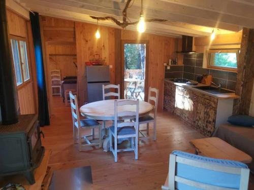 a kitchen and dining room with a table and chairs at Gîte nature L'éveil de la forêt in Vitrac-sur-Montane