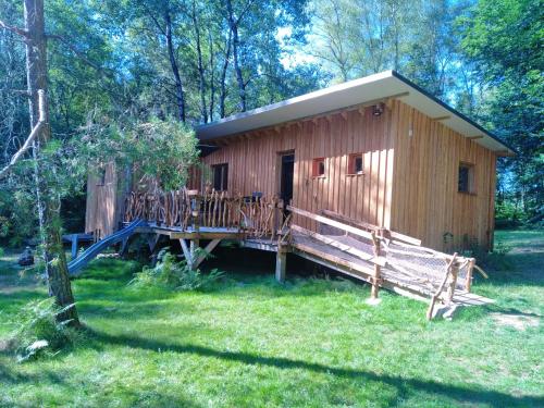 a wooden cabin with a porch and a deck at Gîte nature L'éveil de la forêt in Vitrac-sur-Montane