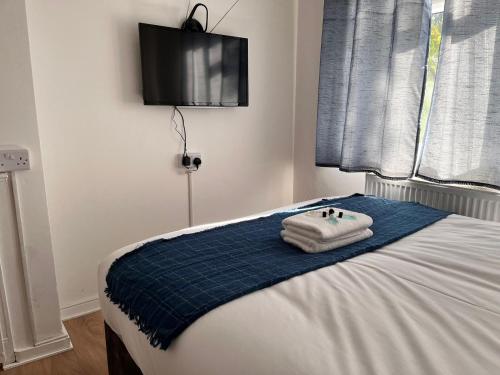 a bedroom with a bed with towels on it at House se3 8rp in London