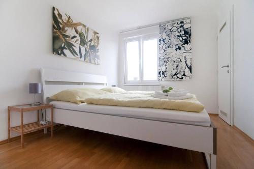 a white bedroom with a large bed in a room at Room in Rooftop Apartment in Vienna