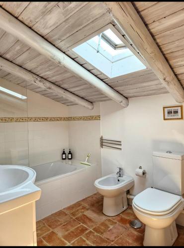 a bathroom with a toilet and a tub and a sink at Casa Aventura in Boliqueime