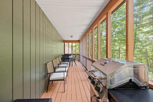 una veranda protetta con sedie e una griglia di Hot Tub, Fire Pit, Grill, Screened Porch & WiFi a Basye