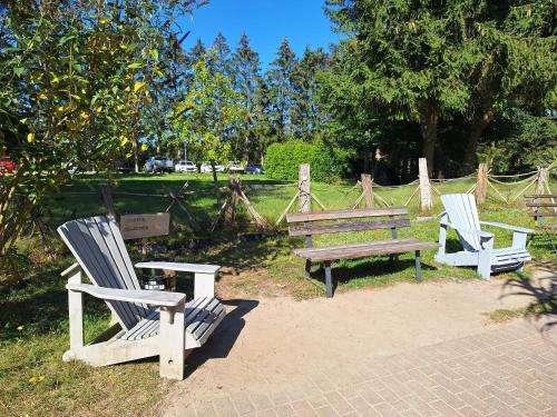 three rocking chairs and a bench in a park at Landidyll Monte Gristow in Mesekenhagen