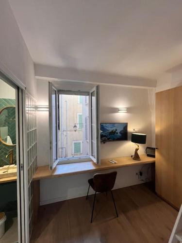 une pièce avec un bureau avec une fenêtre et une chaise dans l'établissement Fishermans House Saint Tropez, à Saint-Tropez