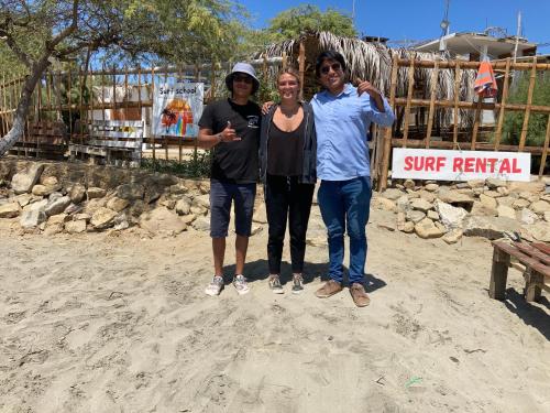 three people posing for a picture on the beach at Casa Tarantini in Lobitos