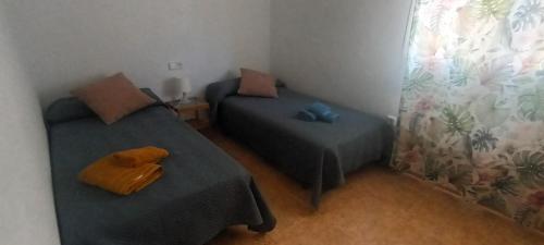 a small room with two beds and a pillow at adosado con piscina en Cabo de Gata 4p in El Cabo de Gata