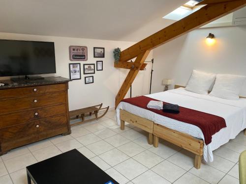 1 dormitorio con 1 cama, TV y vestidor en Gite L'Ô Bleue, en Varces