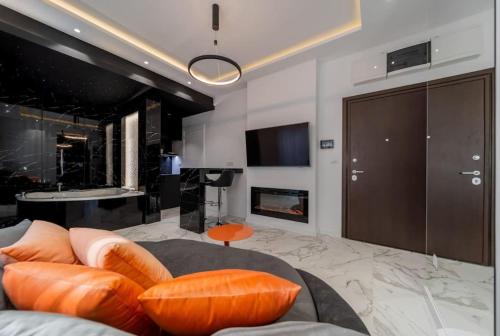 a living room with a couch with orange pillows at Bounce Belgrade Apartment in Vračar (historical)
