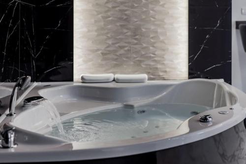 a bath tub with water coming out of it at Bounce Belgrade Apartment in Vračar (historical)