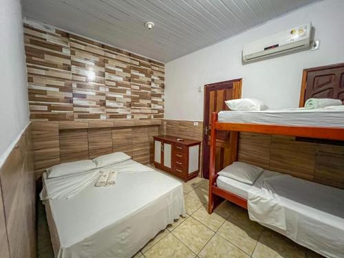 a room with two bunk beds in a room at Pousada Territorial- Segunda praia MSP in Morro de São Paulo