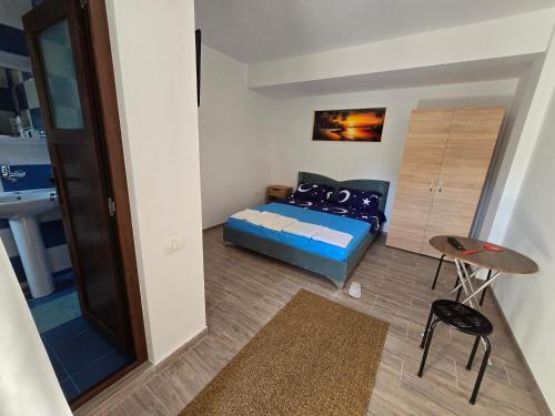 a small room with a bed and a table at Vila VECAS in Eforie Nord