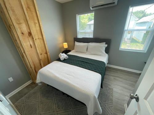 a small bedroom with a bed with white sheets at The Yale Townhouse- 2 BR in Columbus