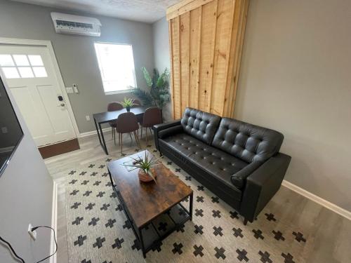 a living room with a black leather couch and a table at The Yale Townhouse 2 - 2BR in Columbus