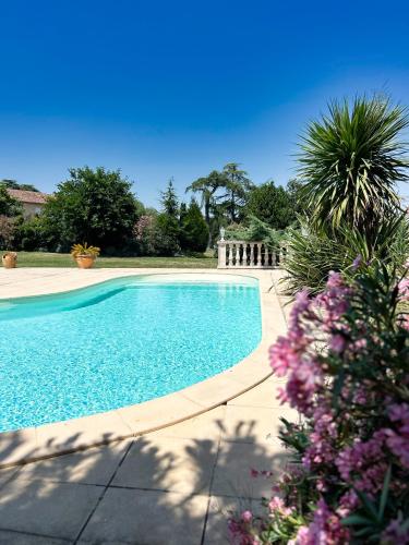 une piscine dans une cour fleurie dans l'établissement Villa GRAZIA - Piscine, à Préchac