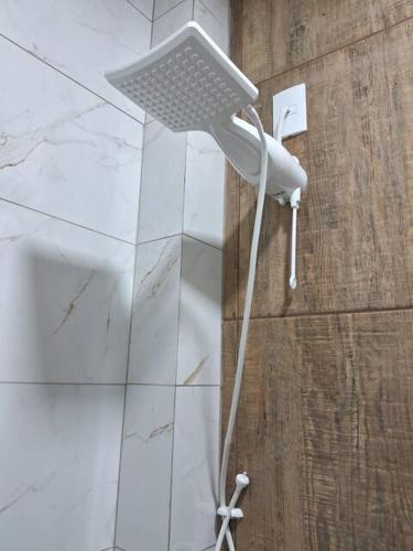 a shower in a bathroom with a phone on the wall at Suite Pedro - Casa Tapera Nova in Conceição da Ibitipoca