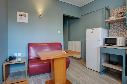 a kitchen with a table and a red chair and a refrigerator at Heliotrope The Studios in Mytilini