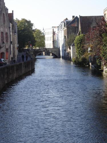 a river with a bridge in a city at B&B Villa Des Raisins in Bruges