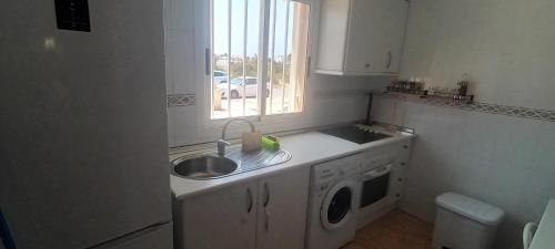 a kitchen with a sink and a washing machine at adosado con piscina en Cabo de Gata 6p in El Cabo de Gata