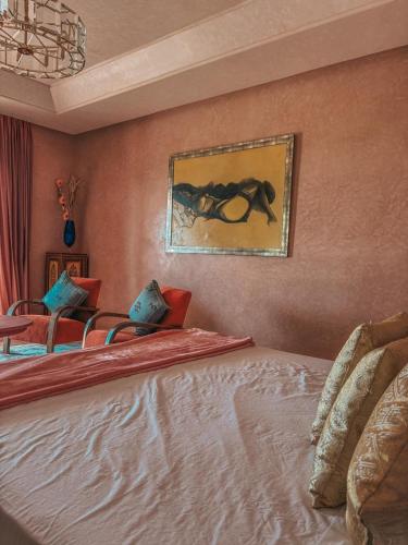 a bedroom with two beds and a painting on the wall at Domaine Golfique Lamrah - 10 Suites in Marrakech