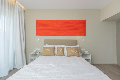 a bedroom with a large white bed with two pillows at Five by Capri 5 Senses in Anacapri