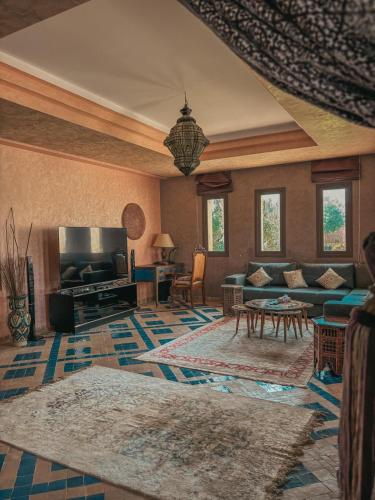a large living room with a couch and a fireplace at Domaine Golfique Lamrah - 10 Suites in Marrakech