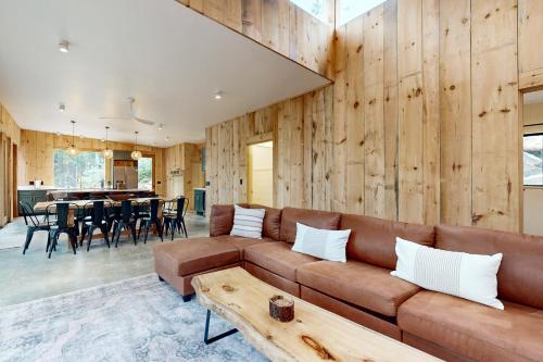 a living room with a brown couch and a table at Hideaway House in Hope