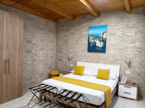 a bedroom with a large bed with yellow pillows at Domos La Corte Ghibellina in Iglesias