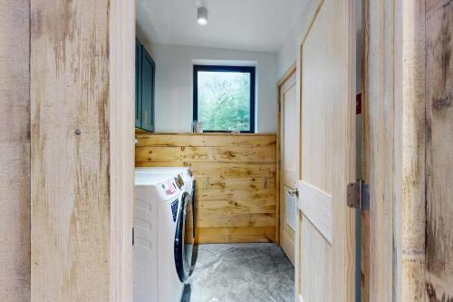 a laundry room with a washing machine and a window at Hideaway House in Hope