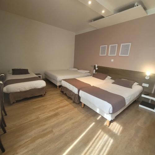 three beds in a room with wooden floors at KYRIAD ORANGE Centre Ville - HOTEL & RESTAURANT & BAR - La Galerie d'Art des Princes - Provence Alpes Côte d'Azur - France - Proche A7-A9 - exit21- Châteauneuf-du-Pape Avignon Bollene Nimes - 24h-24h in Orange