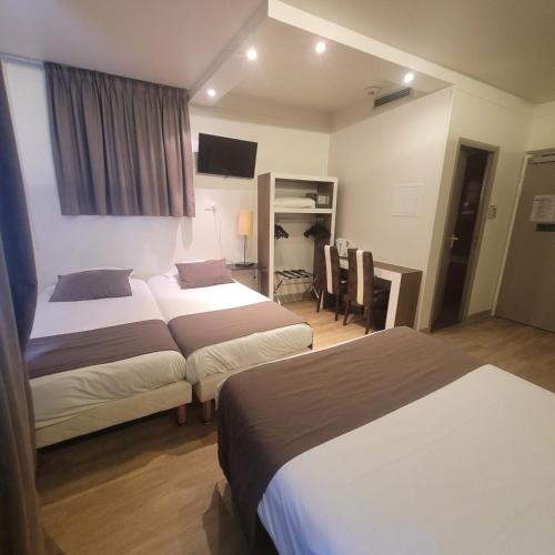 a hotel room with two beds and a desk at KYRIAD ORANGE Centre Ville - HOTEL & RESTAURANT & BAR - La Galerie d'Art des Princes - Provence Alpes Côte d'Azur - France - Proche A7-A9 - exit21- Châteauneuf-du-Pape Avignon Bollene Nimes - 24h-24h in Orange