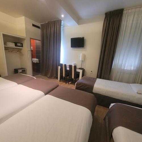 a hotel room with three beds and a television at KYRIAD ORANGE Centre Ville - HOTEL & RESTAURANT & BAR - La Galerie d'Art des Princes - Provence Alpes Côte d'Azur - France - Proche A7-A9 - exit21- Châteauneuf-du-Pape Avignon Bollene Nimes - 24h-24h in Orange