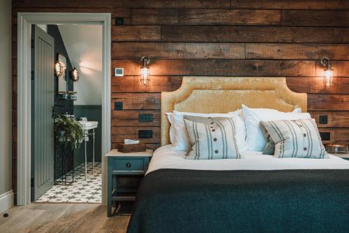 a bedroom with a large bed with a wooden wall at Gara Rock in Salcombe