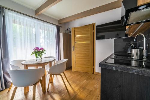 a kitchen and dining room with a table and chairs at Nowa Dana Ośrodek Wypoczynkowy in Łebcz
