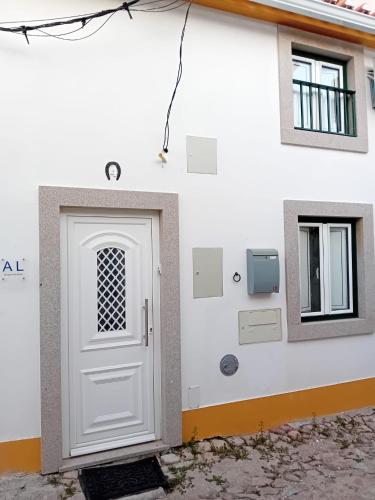 a white door on the side of a building at Casa Madureira in Alpalhão