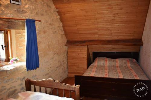 une chambre avec un lit dans une cabane en rondins dans l'établissement Gîte 14 personnes, à Villefranche-du-Périgord