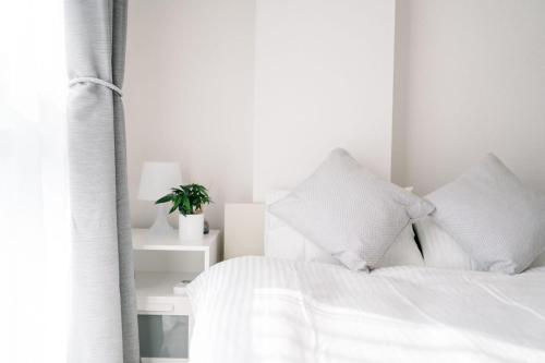 a white bedroom with a bed with white sheets and pillows at 夏美ホテル in Tokyo