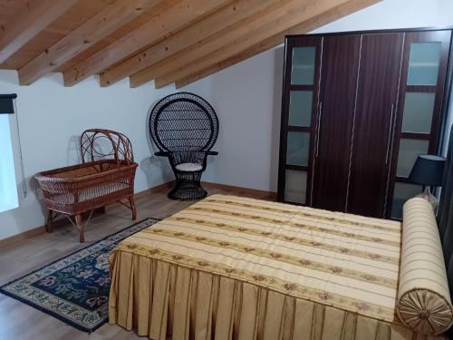 a bedroom with a large bed and a chair at Casa Madureira in Alpalhão