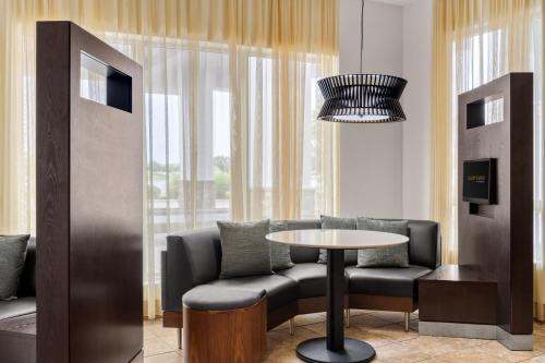 a room with a table and a chair and a window at Courtyard by Marriott Evansville East in Evansville