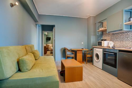 a living room with a couch and a kitchen at Heliotrope The Studios in Mytilini
