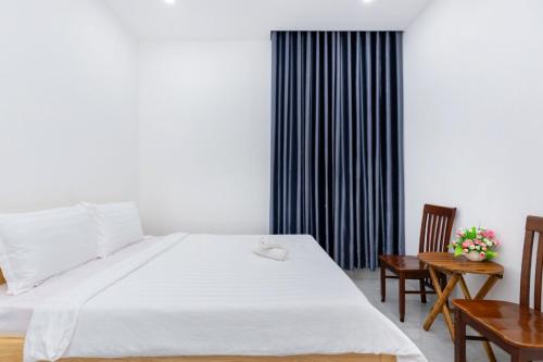a bedroom with a large white bed and two chairs at AMY homestay in Vung Tau