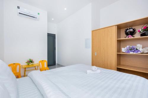 a bedroom with a large white bed and two chairs at AMY homestay in Vung Tau