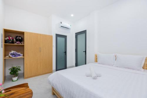 a bedroom with a large white bed and a wooden cabinet at AMY homestay in Vung Tau