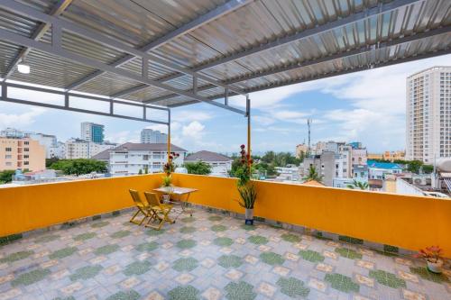 a balcony with a table and chairs on a yellow wall at AMY homestay in Vung Tau