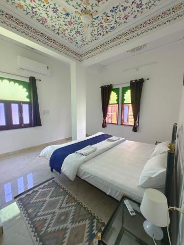 a bedroom with a large bed with a ceiling at Rising Shemesh Home Stay in Udaipur